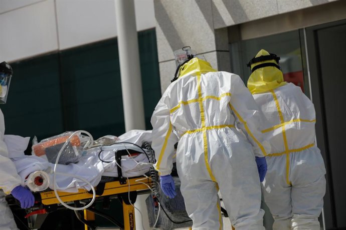 Varios sanitarios trasladan a un paciente desde el interior de una unidad móvil, foto de archivo
