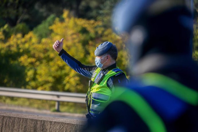 Un agente de policía municipal le da el alto a un vehículo durante un control efectuado en la Carretera de Castilla sentido salida, a la altura del Club de Campo, en Madrid, (España), a 10 de octubre de 2020. Este control, y otros realizados durante el 