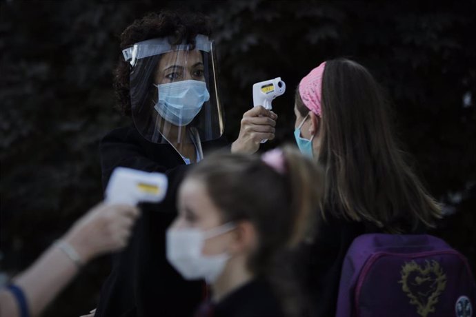 Toma de temperatura a alumnos en un colegio, foto de archivo