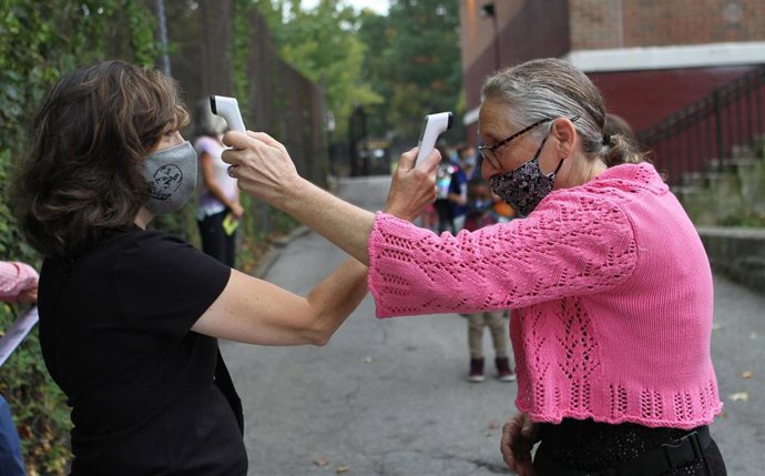 Dos mujeres se toman la temperatura durante la pandemia de coronavirus en Nueva York, Estados Unidos. 
