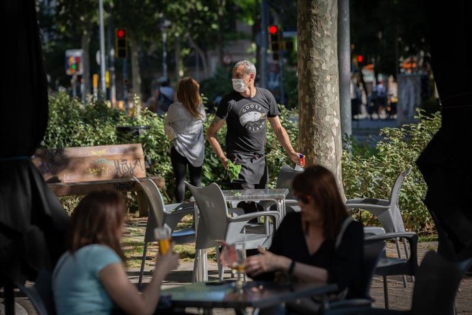 Varias personas disfrutan en la terraza de un bar durante el segundo día de la reapertura al público de las terrazas al aire libre de los establecimientos de hostelería y restauración limitándose al 50% de las mesas y garantizándose una distancia de 2 m