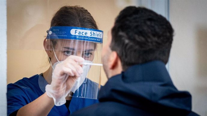 Una trabajadora sanitaria toma una muestra a un hombre para un test de coronavirus
