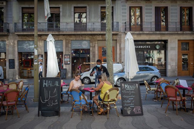 Dues dones mengen a la terrassa d'un bar a Barcelona, Catalunya (Espanya), 14 d'octubre del 2020.