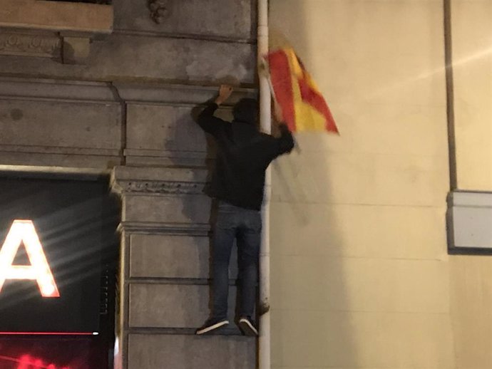 Manifestante retirando una bandera española
