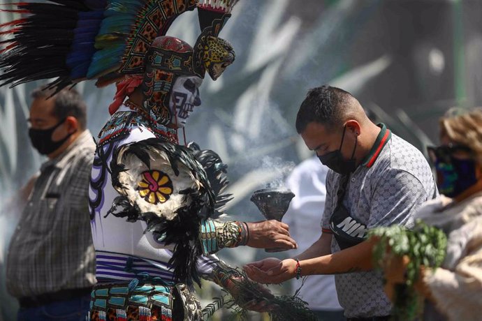 Un grupo de personas se someten a una 'limpia' de espíritu de los llamados concheros  en la céntrica plaza de El Zócalo, en Ciudad de México.