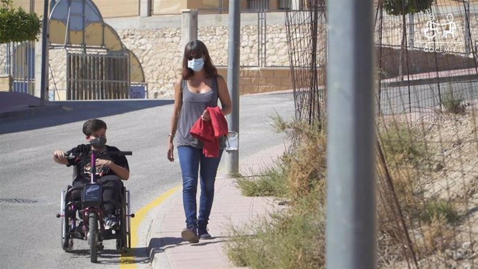 Un joven con discapacidad acompañado de una mujer.