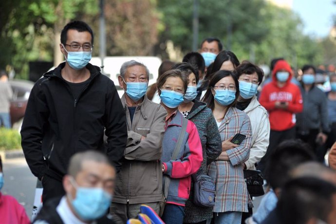 Personas esperan en una cola para someterse a pruebas de coronavirus en Qingdao