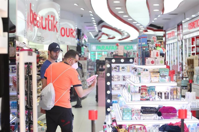 Dos clientes miran productos en una tienda de cosméticos  