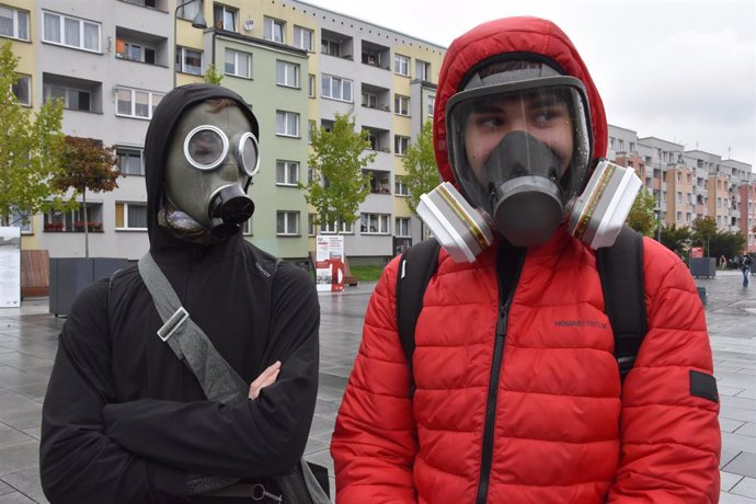 Dos personas con máscaras de gas en Polonia después de que las autoridades hayan obligado a usar mascarilla por la pandemia