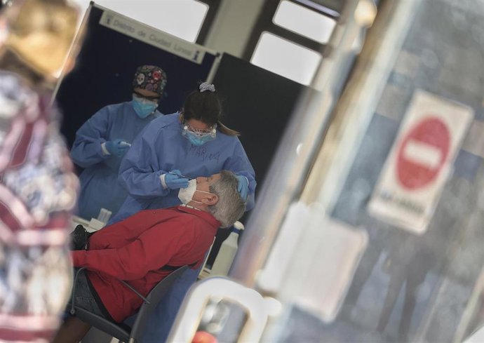 Una sanitaria toma muestras a un hombre para realizar un test de antígenos, foto de archivo