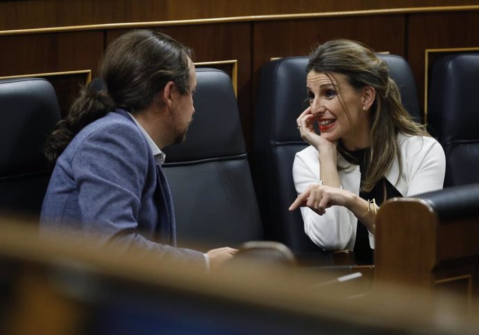 La ministra de Trabajo, Yolanda Díaz, habla con el vicepresidente  Pablo Iglesias, en el Congreso
