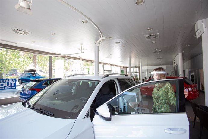 Una trabajadora abre un coche aparcado en el interior de uno de los concesionarios reabiertos en la Fase 1 de desescalada, foto de archivo
