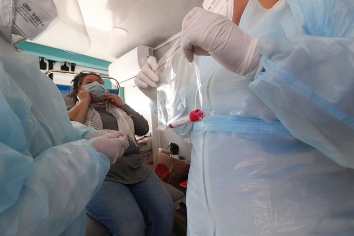 09 October 2020, Chile, Vina Del Mar: A woman puts her face mask back on after undergoing a PCR test at a Covid-19 testing station. Photo: Leonardo Rubilar/Agencia Uno/dpa