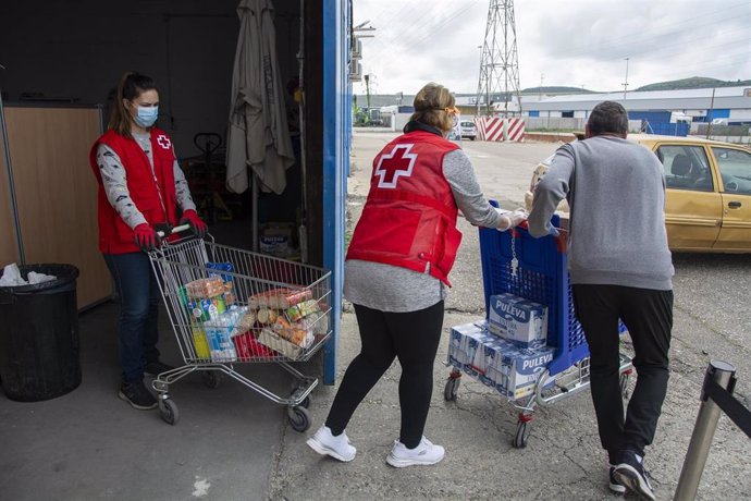 Voluntarios de Cruz Roja con carros de alimentos