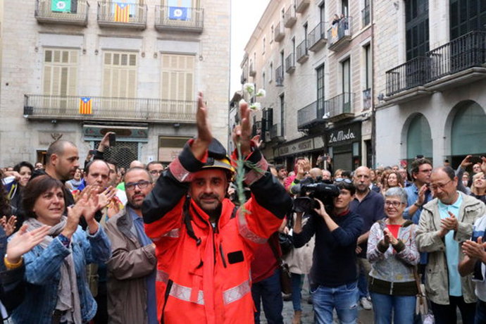 Pla mig d'un bomber tornant els aplaudiments a la Plaa del Vi de Girona el 2 d'octubre del 2017, durant la concentració que es va fer (Horitzontal)