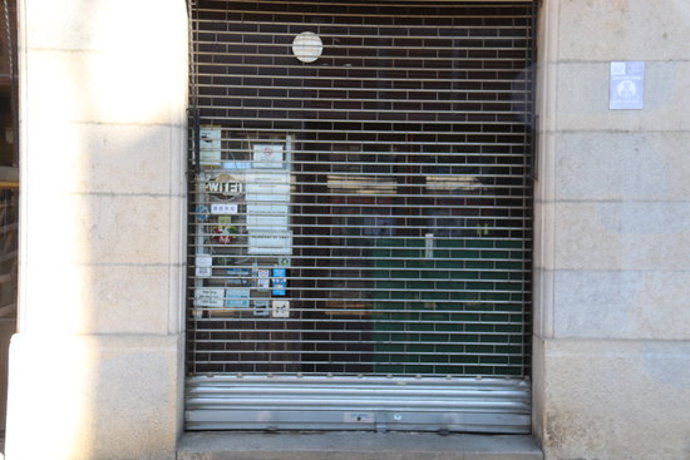 Pla obert de dues persones esmorzant en un banc després de comprar un entrep i un caf per emportar al carrer d'Hortes de Girona el 16 d'octubre de 2020 (Horitzontal)