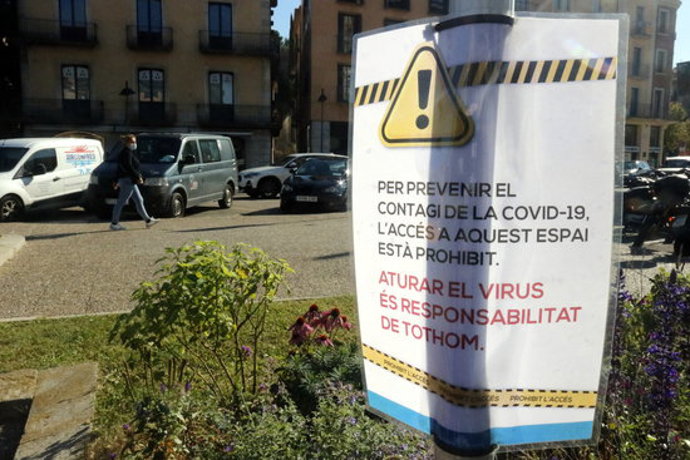 Pla general d'un cartell alertant que els jocs infantils estan tancats per la covid-19, aquest 16 d'octubre del 2020 a Girona (Horitzontal)