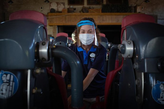 Una treballadora de PortAventura World protegida amb mascareta i pantalla.