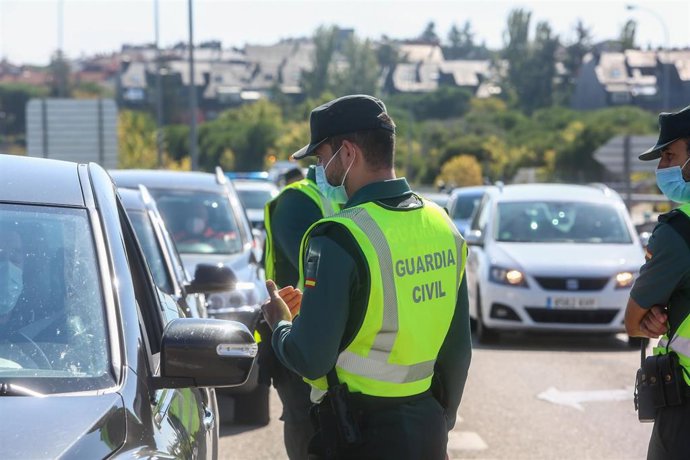 Un agente de la Guardia Civil vigila durante un control en la A-6, en Madrid, por el estado de alarma en la región