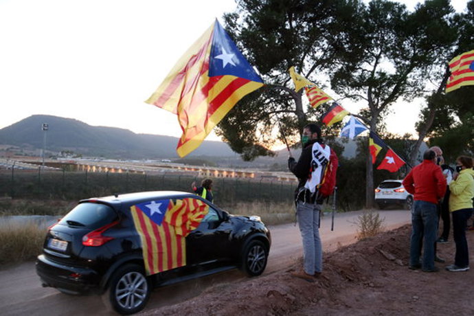 Al fons, la presó de Lledoners, i, en primer pla, vehicles i gent amb estelades durant la rua de cotxes. 16 d'octubre de 2020. (Horitzontal)