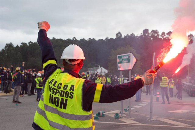 Un trabajador sostiene una bengala durante una nueva manifestación convocada por el Comité de Alcoa en la que cortan el tráfico en la carretera N-642 y el acceso al corredor C.G.2.3 a la altura de Lago, en Xove, Lugo