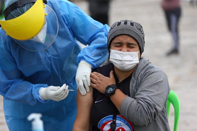 Un sanitario saca sangre a una mujer en Lima