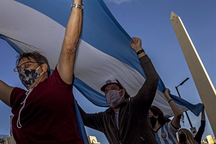 Varias personas sujetan una bandera Argentina en una manifestación anti-cuarentena en Buenos Aires.