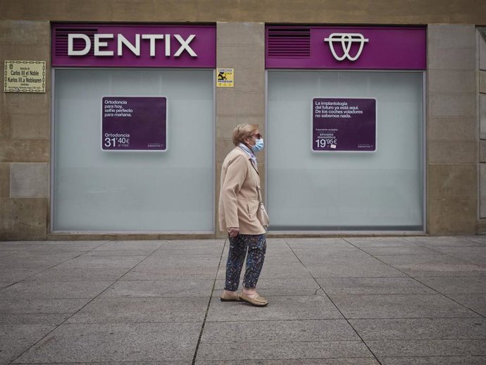 Una mujer paseas enfrente de una clínica Dentix