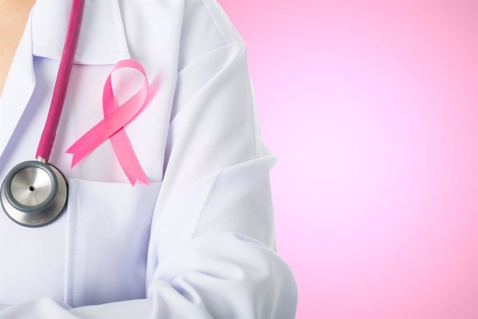 Médico con un lazo rosa por el Día internacional contra el cáncer de mama.