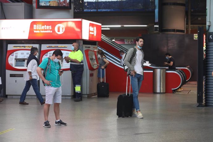 Varias personas sacan billetes en la estación de Renfe Madrid Puerta de Atocha en el primer día laborable tras el estado de alarma, en Madrid (España), a 22 de junio de 2020.