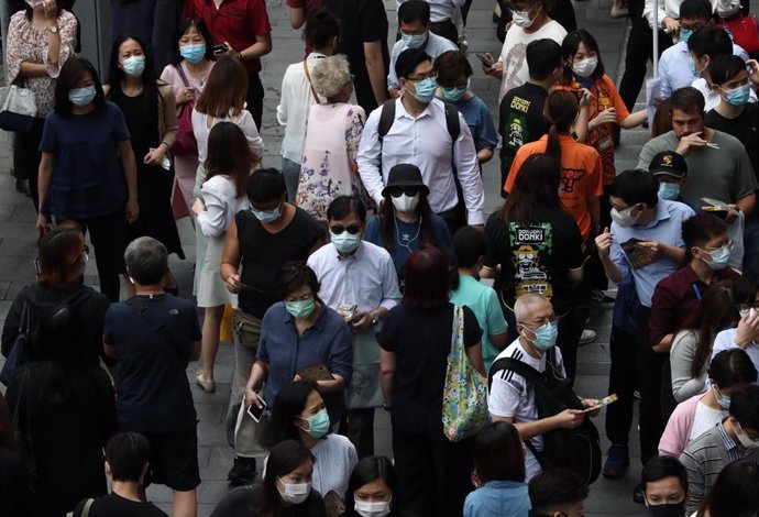 Un grupo de personas guarda su turno para poder entrar en una conocida tienda de dulces de una cadena japonesa en Hong Kong.