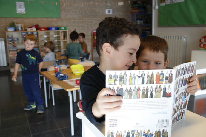 Primer pla d'uns nens mirant un llibre de gegants a l'escola Cor de Roure de Santa Coloma de Queralt (Conca de Barber). Imatge publicada el 19 d'octubre del 2020. (Horitzontal)