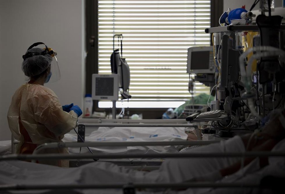 Un sanitario atiende a un paciente en la Unidad de Cuidados Intensivos (UCI)