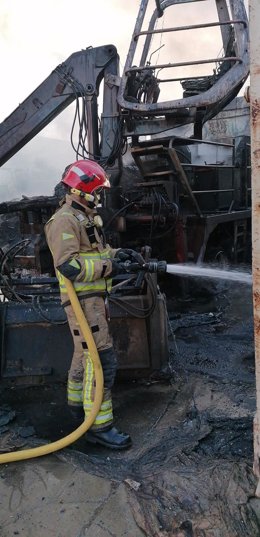 Un bombero trabaja en la extinción de un incendio declarado en una planta de reciclado de Torre Pacheco