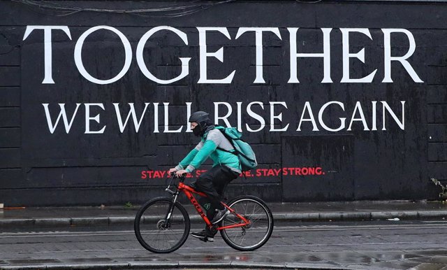 Un ciclista pasa ante un mural por el centro de Dublín