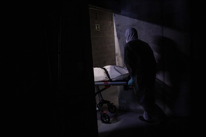 Varios operarios protegidos de los Servicios Funerarios Memora trasladan un cuerpo de una residencia  en el garaje de una residencia de ancianos para recoger el cuerpo de una persona fallecida con Covid-19 para trasladarlo al Crematorio de Girona, duran