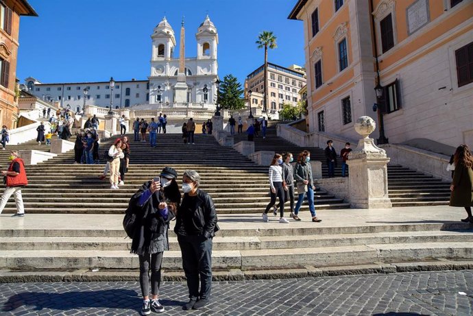 Turistas con mascarilla en la Plaza de España en Roma