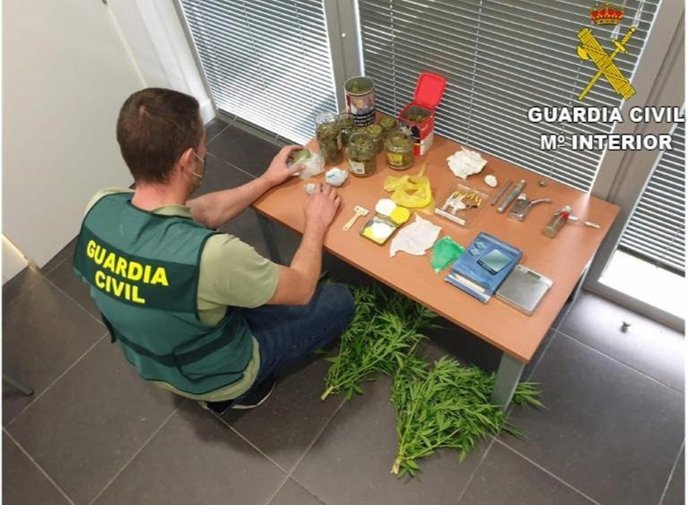 Un agente de la Guardia Civil con parte de la droga intervenida.