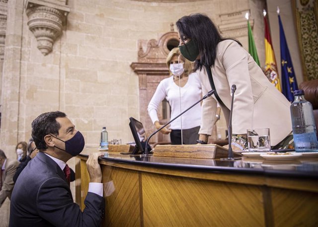 El presidente de la Junta de Andalucía, Juanma Moreno, saluda este miércoles a la presidenta del Parlamento, Marta Bosquet, que ha vuelto tras superar el Covid-19, durante la segunda jornada del Debate sobre el Estado de la Comunidad