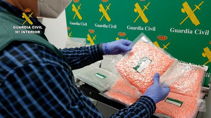 Imatge policial d'un agent de la Gurdia Civil intervenint diversos paquets amb pastilles d'MDMA trobats entre l'equipatge d'un conductor. Imatge publicada el 21 d'octubre del 2020 (horitzontal)
