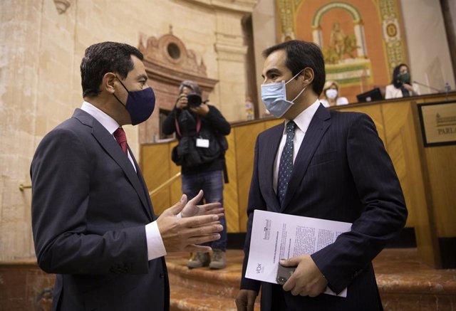El presidente de la Junta de Andalucía, Juanma Moreno (i), junto al portavoz del grupo parlamentario popular, José Antonio Nieto, al inicio de la segunda jornada del Debate sobre el Estado de la Comunidad en el Parlamento de Andalucía