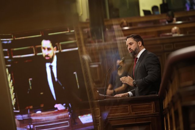 El presidente del Gobierno, Pedro Sánchez (d), escucha sentado al presidente de VOX, Santiago Abascal, durante el pleno en el que se debate la moción de censura planteada por Vox, en el Congreso de los Diputados, Madrid (España), a 21 de octubre de 2020