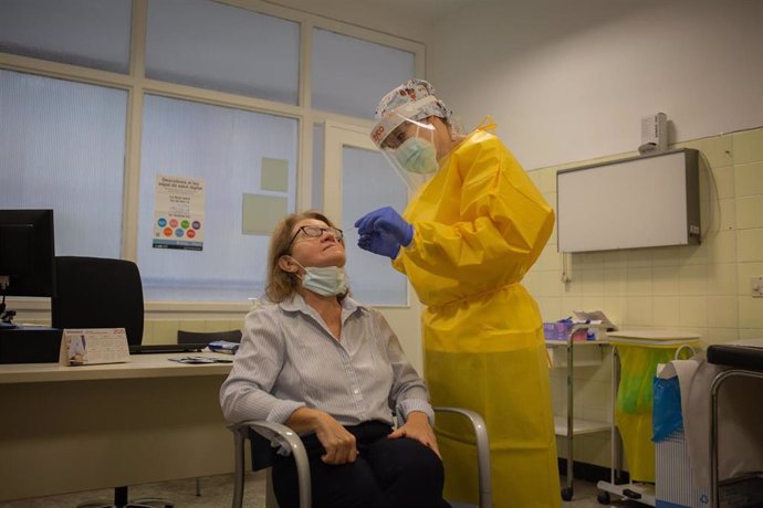 Una sanitaria realiza un test rápido de antígenos de detección de coronavirus a una doctora del Centro de Atención Primaria CAP Manso, en Barcelona