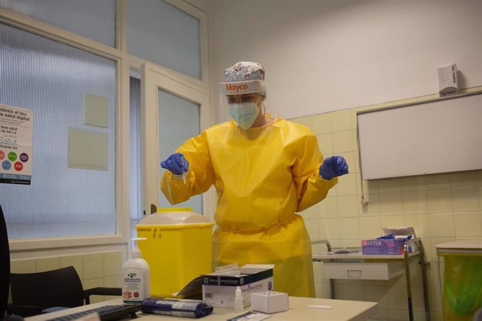 Una sanitaria introduce en una papelera habilitada restos de materiales utilizados para realizar test rápidos de antígenos 
