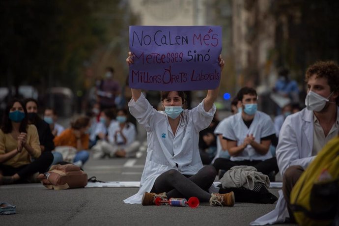 Una profesional sanitaria sostiene un cartel en el que se lee 'No calen més metgesses sinó millors drets laborals' en una nueva concentración de Médicos Internos Residentes (MIR)