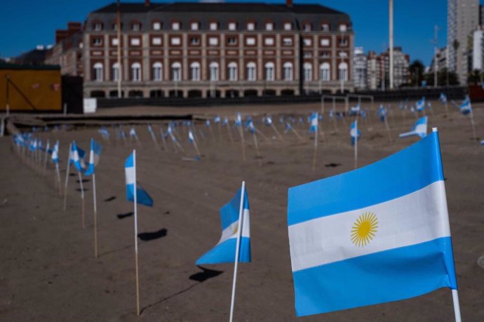 Banderas argentinas sobresalen de la arena de una playa en memoria de las víctimas del coronavirus, en la ciudad costera de Mar del Plata.