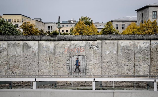 Un hombre con mascarilla pasando ante un muro de un museo en Niederkirchnerstrasse, en Berlín