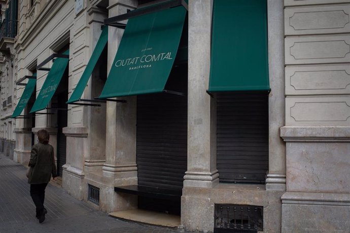 Una mujer pasa junto a un restaurante cerrado durante el cuarto día de la entrada en vigor de las nuevas restricciones en Cataluña, en Barcelona, Cataluña (España) a 20 de octubre de 2020. El pasado viernes 16 de octubre entraron en vigor las nuevas res