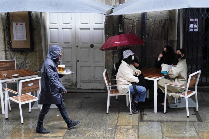 Una camarera lleva varias cervezas a una de las mesas de la terraza de su establecimiento, en Santiago de Compostela, A Coruña (Galicia), a 22 de octubre de 2020. 