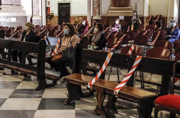 Varias personas asisten a una misa en la Basílica de Valencia